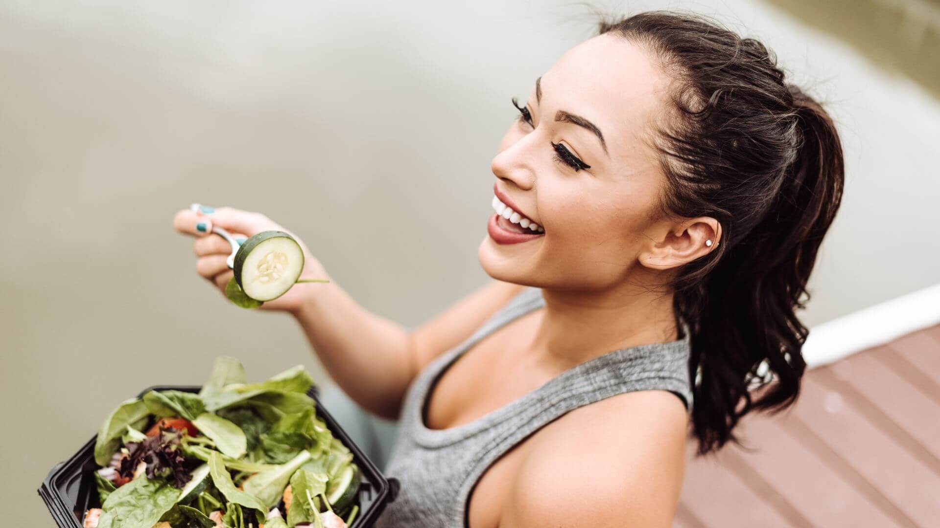 a woman eating a salad on a dock