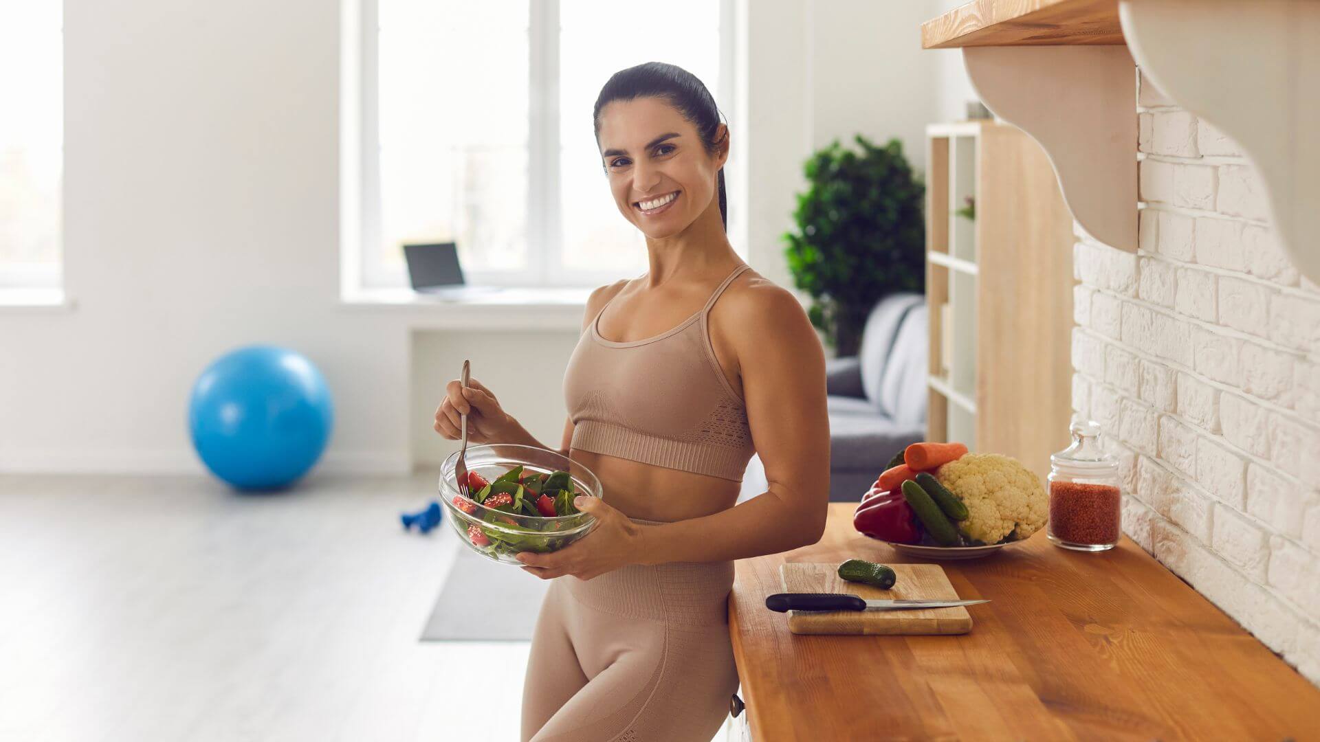 a woman is holding a bowl of salad in front of a kitchen