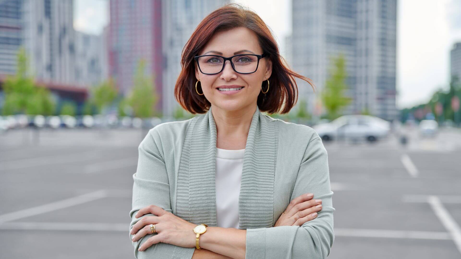 a business woman in glasses standing in a parking lot